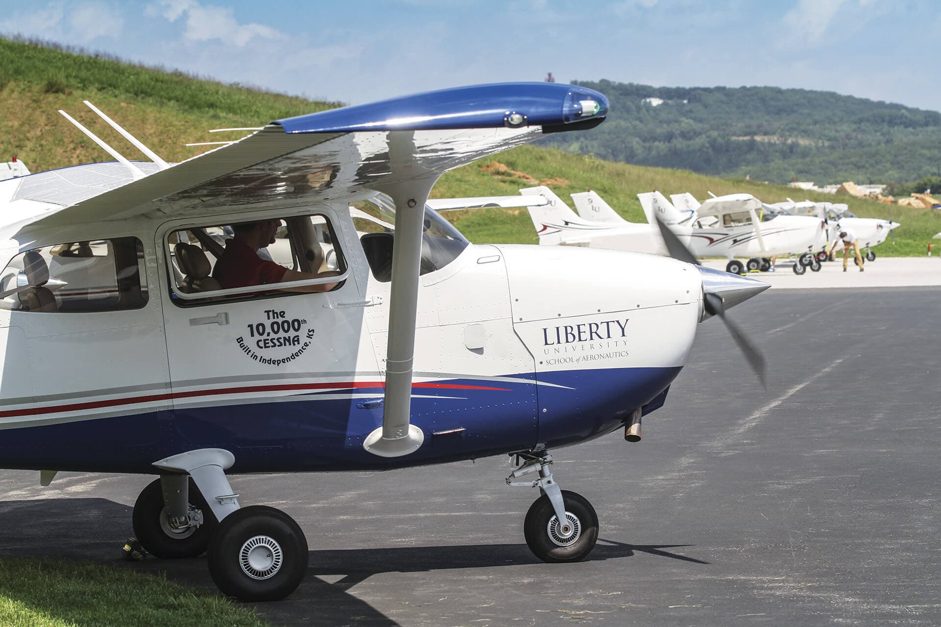 Light training aircraft parked on the apron at a general aviation airfield