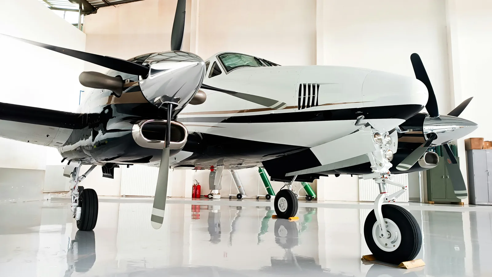 Light business aircraft parked inside a bright private hangar