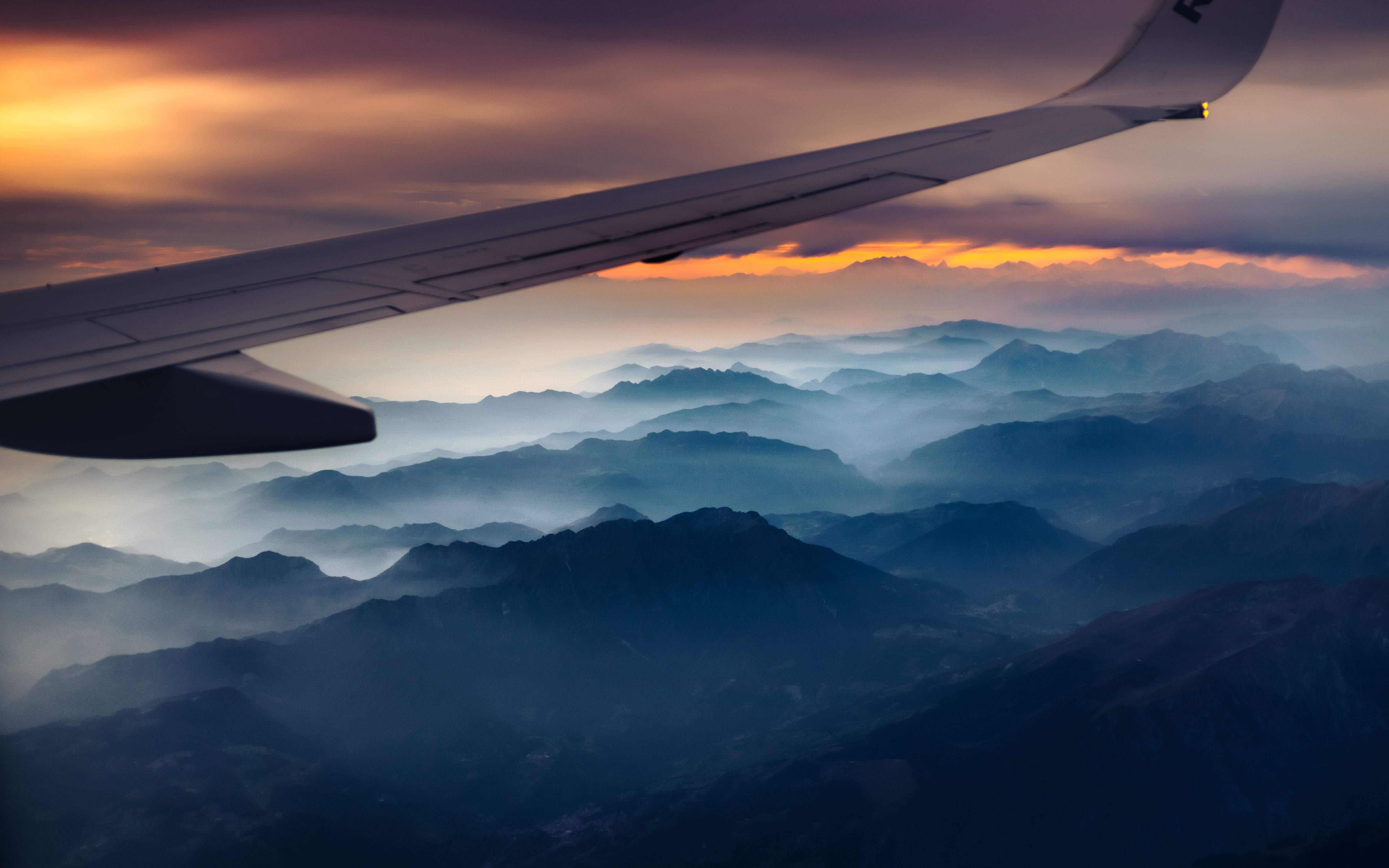 Airline wing above the Alps at twilight