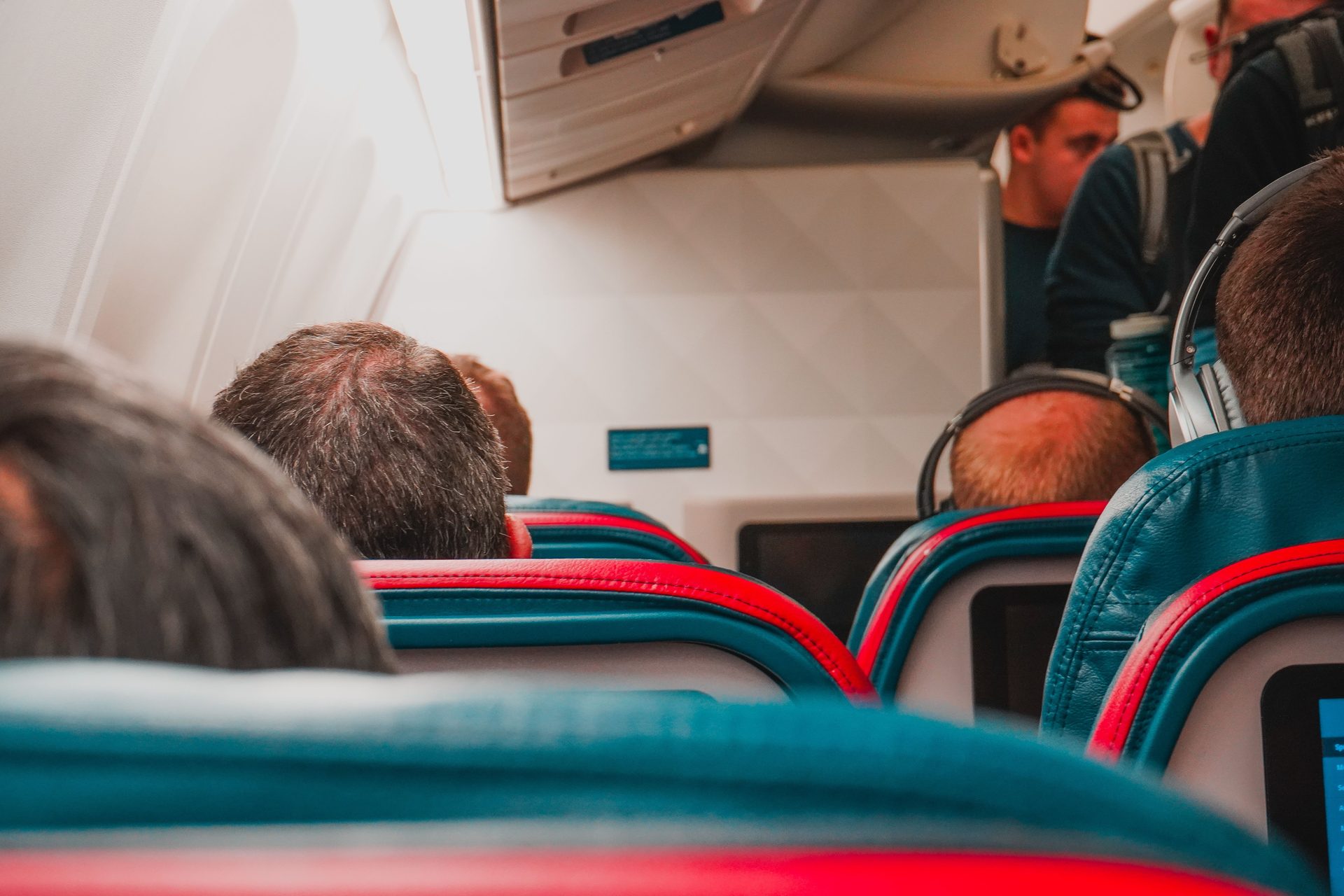 Passengers seated inside a commercial airplane cabin, focusing on seats and the passenger experience
