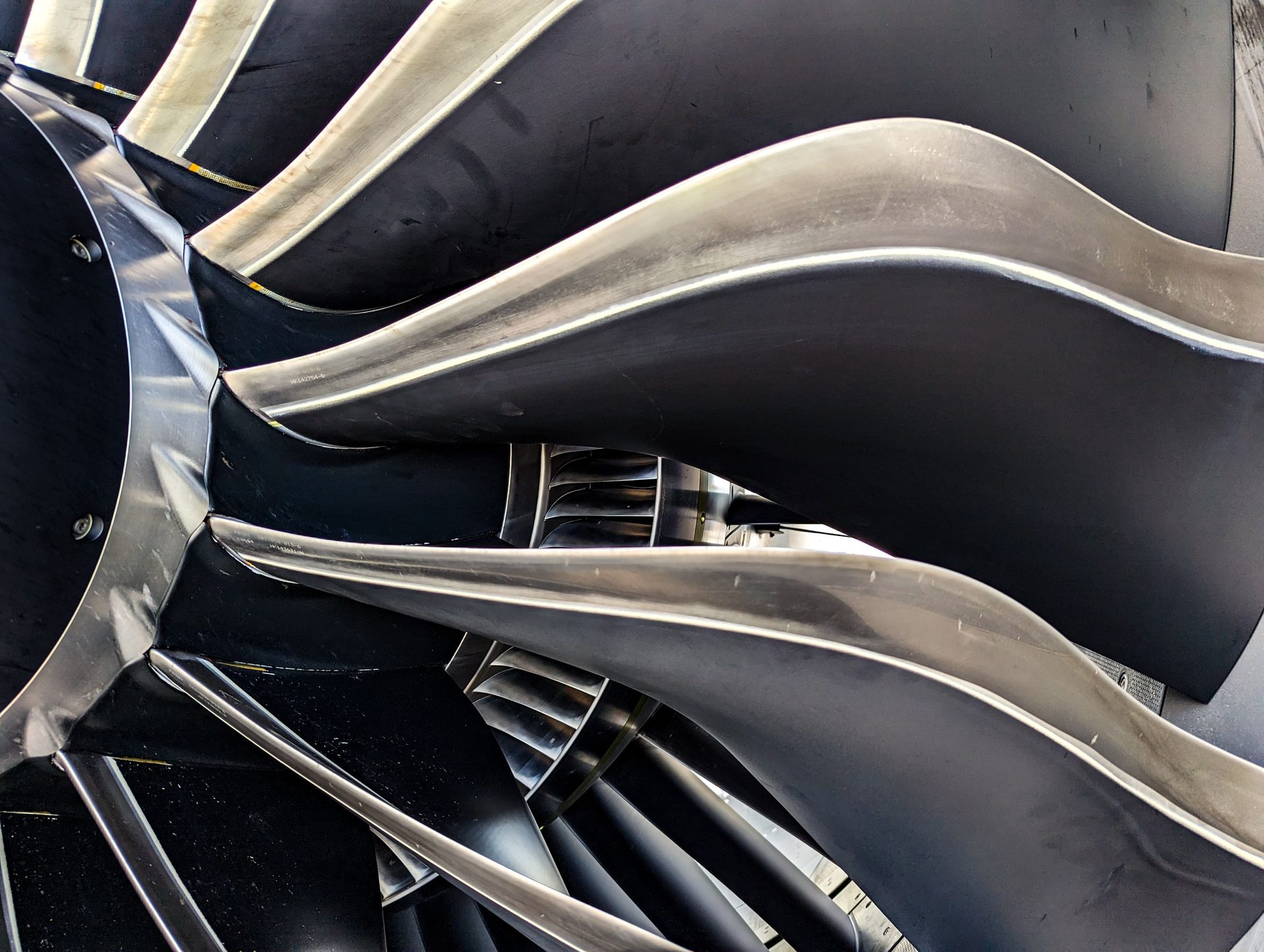 Close-up of precision-machined jet engine fan blades with aerodynamic twist