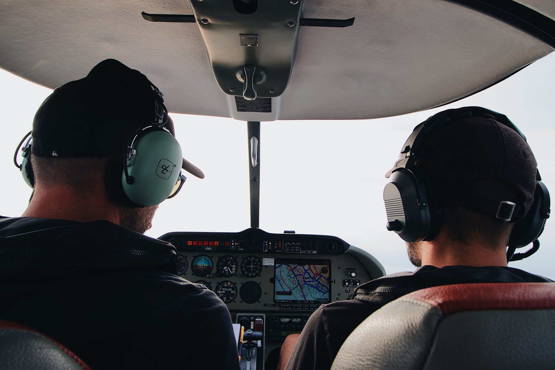 Two pilots at the controls of a light aircraft cockpit